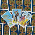 Tarot kortos Rider–Waite stiliaus, mėlynos nugarėlės su auksiniu ornamentu, trijų Lazdų kortų išklotinė iš viršaus