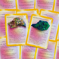 Kristalinės orakulo kortos su Bismuth ir Azurite Malachite kortomis, ryškiais geltonais kraštais ir rožiniu fonu, parodytos iš viršaus