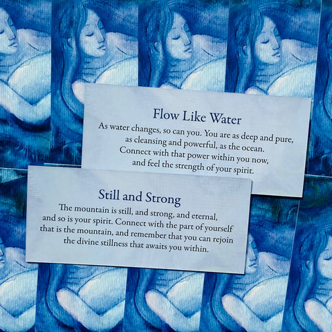 Meditacinės kortelės su „Flow Like Water“ ir „Still and Strong“ tekstais mėlyname fone, parodytos kaip dviejų variantų pavyzdys
