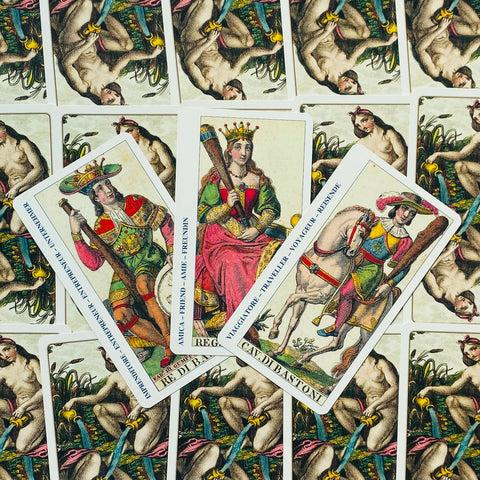 Tarot kortos – itališkas tradicinis rinkinys su karalienės, karaliaus ir riterio bastonų kortomis ant raštuoto fono, trijų kortų dėliojimas