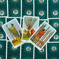 Tarot kortos Rider–Waite, trimis atverstomis ietų kortomis (Page, Nine, Ten) ant turkio raštuoto nugarėlio