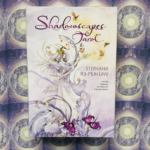 Shadowscapes Tarot kortų rinkinys su Stephanie Pui‑Mun Law iliustruota pastelinė balta–violetinė dėžute ir foninėmis kortomis