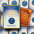 Crystal Mandala Oracle orakulo dėžutė mėlyno su aukso rėmu, priekyje atidengta raudona korta su saulės motyvu, skirta produkto pristatymui