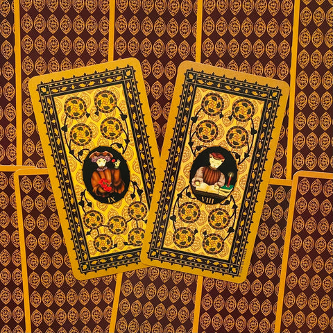 Tarot kortos su aukso ir bordo nugarėlėmis, dvi išskirtinės kortos (IX ir VIII pentaklių) parodytos iš viršaus, pabrėžiant detalius ornamentus ir skirtumą nuo kitų variantų