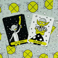 taro kortos žaismingos geltonos–juodos spalvos, dvi kortos (Page of Probes ir Ten of Probes) ant planetų fono