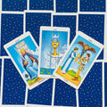 Tarot kortos Rider‑Waite stiliaus, mėlynos nugarėlės su geltonomis žvaigždėmis, trijų kortų išklotinė centrinė Ace of Cups