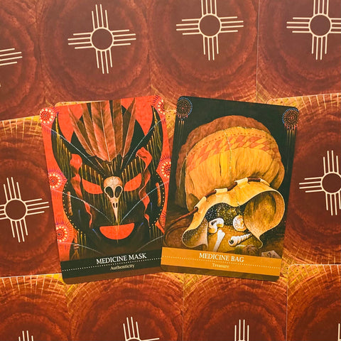 Orakulų kortos, dvi atverstos kortos: kairėje ryški raudona „Medicine Mask“ (Autentiškumas), dešinėje gelsva „Medicine Bag“ (Lobis)