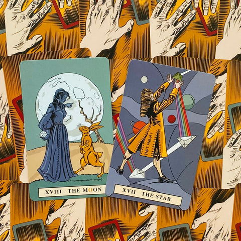 Tarot kortos iliustruotas rinkinys — dvi atviros kortos (XVIII Mėnulis ir XVII Žvaigždė) ant ryškaus rankų kortų nugarėlių fono, parodytas priekis ir dizaino kontrastas