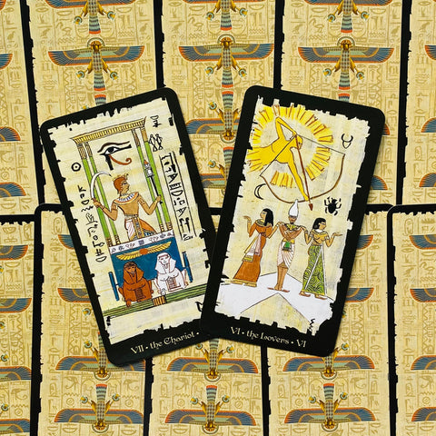 Tarot kortos egiptietiško papiruso dizaino su juodais kraštais, kampu atverstos kortos „Chariot“ ir „Lovers“ — skirtos skaitymui ir dovanai