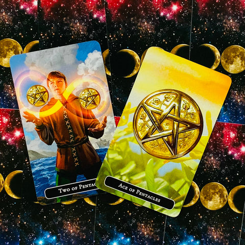 Tarot kortos su Pentaklių motyvais: dvi atverstos kortos (Ace ir Two), auksinės detalės, geltonai‑mėlynas fonas ir įstriža kompozicija ant mėnulio kosmoso fono