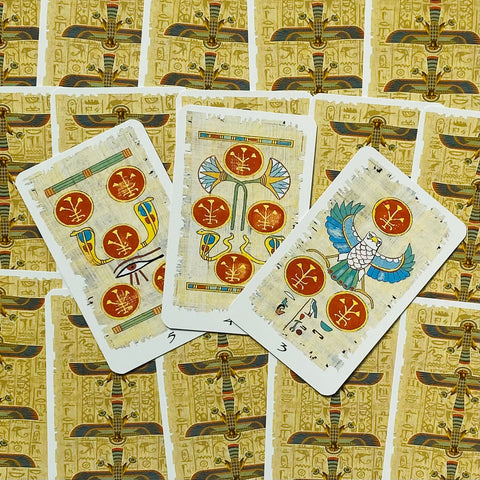 tarot kortos egiptietiško dizaino su papiruso fonu, trys atvertos priekio kortos, aiškūs raudoni simboliai