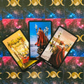 Tarot kortos trijų kortų išdėstymas: geltona Keturių lazdų, mėlyna Trys lazdos ir ruda Dviejų lazdų kortos ant kosminio mėnulio nugarėlių