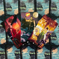 Tarot kortos su trimis atversto dizaino kortomis — raudona pianistė, vyras su fakelu ir žalia panelė ant karuselės, kortų nugarėlė su mėnulio pilimi