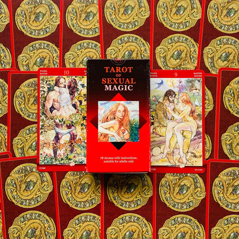 Tarot kortos Sexual Magic raudoname dėkle, centrinis planas su dviem iliustruotomis kortomis šonuose ir aukso ornamentais