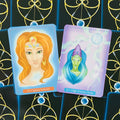 Tarot kortos su atvertais priekiais, rodantys Queen Nefertiti oranžinę ir High Priestess Naito mėlyno‑žalią kortas ant juodai‑auksinio fono