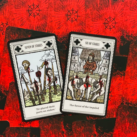 Tarot kortos kraupiomis iliustracijomis — atverstos šešių ir septynių kuolų kortos ant raudono, grubių nugarėlių fono