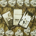 Tarot kortos trijų kortų išdėstyme: gyvatės, kupranugarių ir vaikų piešiniai matomi prie detalios ornamentuotos nugarėlės