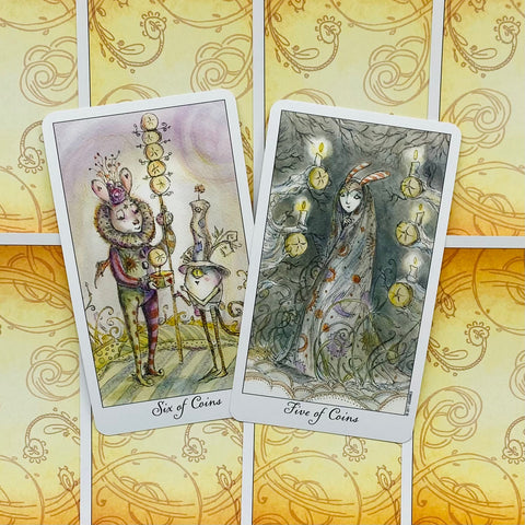 Tarot kortos – Šeši monetų ir Penki monetų kortos su paslaptingais piešiniais ant geltono ornamentuoto fono