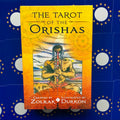 Tarot kortos The Tarot of the Orishas geltonas viršelis su medituojančiu personažu, detalus dėžutės priekis parduotuvės sąraše