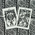 Tarot kortos juodai baltos, dvi atidengtos kortos – 6 vainikas ir 5 lazdos, gėlių nugarėlė
