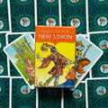 Produktų puslapyje — geltona „Tarot of the New Vision“ dėžutė centre su trimis išskleistomis kortomis ant žalsvai mėlyno raštuoto fono