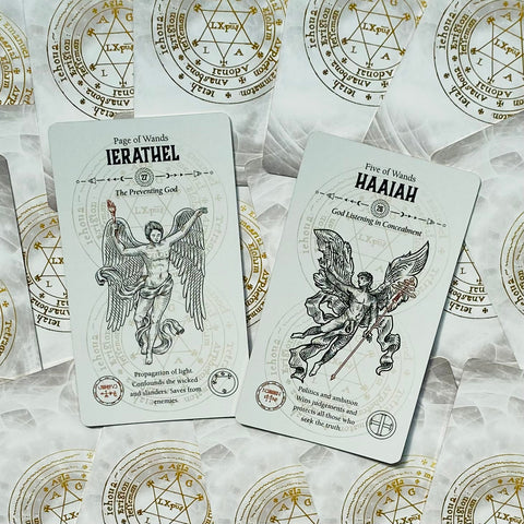Tarot kortos atviros: baltos kortos su auksiniu magiškų simbolių fone, Ierathel ir Haaiah variantai kampu išdėstyti