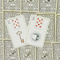 Lenormand kortos: dvi atidengtos kortos — Raktas ir Mėnulis — gulsčiai ant dekoratyvių nugarėlių, artimas planas