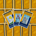 Tarot kortos su geltoniomis ir mėlynomis nugarėlėmis, plokščiai išdėliotos ir atverstos centrinėse Kardų ir Monetų kortose, pabrėžia šio dizaino variantą