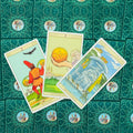 Tarot kortos su ornamentuotomis nugarėlėmis, trijų kortų variantas — Pentaklių tūzas centre; 2 pentakliai kairėje; apverstas puodelių karalius dešinėje