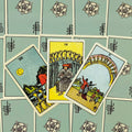 Tarot kortos Rider–Waite stiliaus su melsvomis nugarėlėmis, trys atverstos taurės (VIII, IX, X) centre viršaus kampu