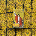 Produktų puslapyje: Golden Universal Tarot dėžutė vertikaliai su mago figūra raudonais rūbais, apsupta aukso ornamentuotų kortų nugarėlių