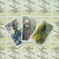 Tarot kortos – trys atverstos kortos (Puslapis, Dešimt ir Devynios kalavijai) su smulkiais akvareliniais piešiniais, parodytos priekiniu dizainu