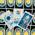 Tarot kortos su akvarelinėmis „Vandens“ kortomis, trijų kortų išklotinė ant juodo fono su spalvotais simboliais