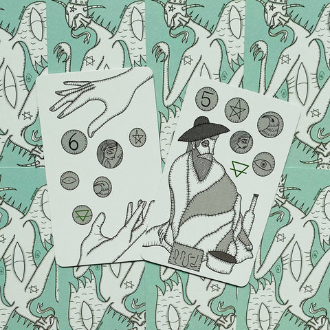 Tarot kortos atverstos iš viršaus, dvi kortos su rankų ir vyro iliustracijomis ant mėtininio fono, parodyta dizaino detalė