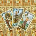 tarot kortos Art Nouveau komplektas — trys taurės aukštyn išrikiuotos kortos ant ornamentinės auksinės nugarėlės