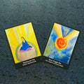 Tarot kortos — dvi spalvingos akvarelinės kortos (meditacija ir rankos su širdimi), nuotrauka iš viršaus ant tamsaus raštuoto fono