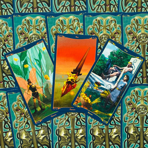 Tarot kortos su žaliai mėlynomis nugarėlėmis, trijų kortų išklotinė parodyta priekinėmis iliustruotomis kortomis