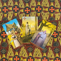 Tarot kortos atverstos trijulė: 2, 3 ir 4 lazdų kortos ant raudono‑geltono ornamentuoto fono, parodytos priekinės pusės