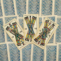 Tarot kortos Piacenza stiliaus: trys skirtingos lazdelės (V, VII, VIII) išdėstytos ant mėlynos nugarėlės, matomas priekinis detalus variantas
