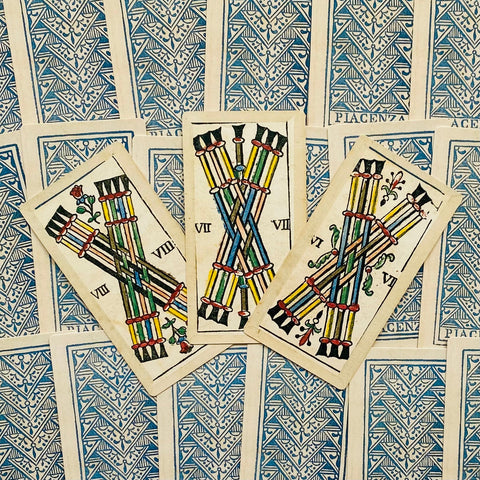 Tarot kortos Piacenza stiliaus: trys skirtingos lazdelės (V, VII, VIII) išdėstytos ant mėlynos nugarėlės, matomas priekinis detalus variantas