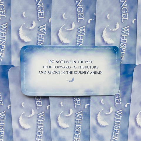 Angel Whisper kortos, mėlynas variantas, centre atversta korta su įkvepiančia žinute apie ateitį ir kelionę, matoma plunksna