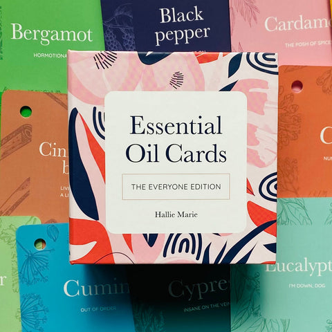 Essential Oil kortelės – rožinė „The Everyone Edition“ dėžutė centre, matomas autorius Hallie Marie ir spalvoti aromatų kortelių fonai