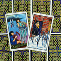 tarot kortos Rider–Waite stiliaus, dvi atviros kortos (VII ir VIII kalavijų) ant juoda‑auksinės nugarėlės