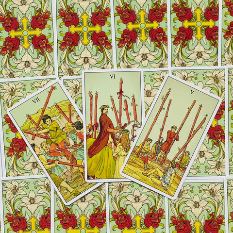 Tarot kortos trijų lazdelių išklotinė ant pastelinės žalsvos nugarėlės, centrinė VI korta iškelta ir ryškesnė už kitus variantus
