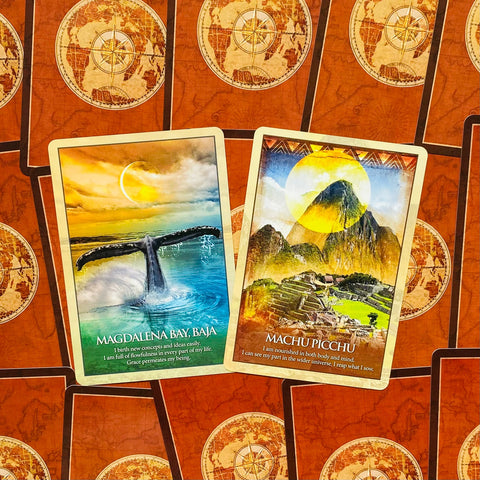 Orakulo kortos, dvi atverstos kortos "Magdalena Bay" ir "Machu Picchu", ryškios spalvos ant oranžinės žemėlapio nugarėlės