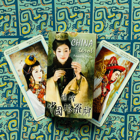 China tarot kortų rinkinys, dėžutė centre ir dvi atverstos kortos šone ant turkio raštuoto fono, skirtas kolekcijai ar dovanai