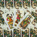 tarot kortos su trimis išdėstytomis didžiosiomis kortomis centre, spalvingi istoriniai personažai ir kortelių nugarėlė fone