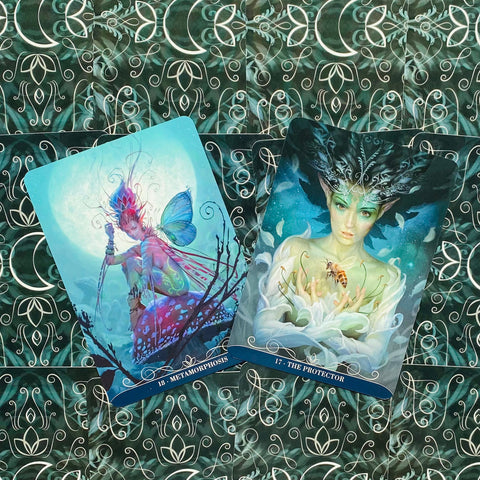 Tarot kortos, dvi atviros kortos (Metamorphosis ir The Protector) ant žaliai dekoruoto fono, matomos priekio iliustracijos