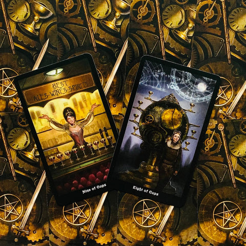 Tarot kortos steampunk nugarėle, dvi atviros kortos — Devynios taurės ir Aštuonios taurės — priekis ant ornamentuoto fono