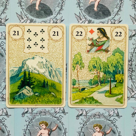 Lenormand kortos, dvi atverstos: 21 Kalnas ir 22 Kryžkelė, artimas planas ant mėlyno ornamentuoto fono